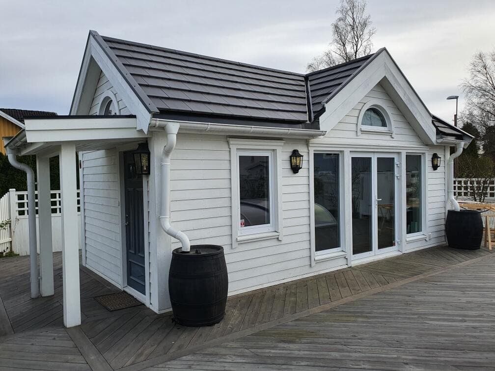 Gästhus med vitmålad panel och snickerier