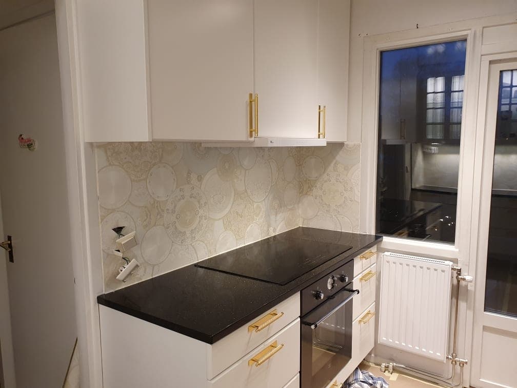 Köksdel med målade luckor vid fönstret