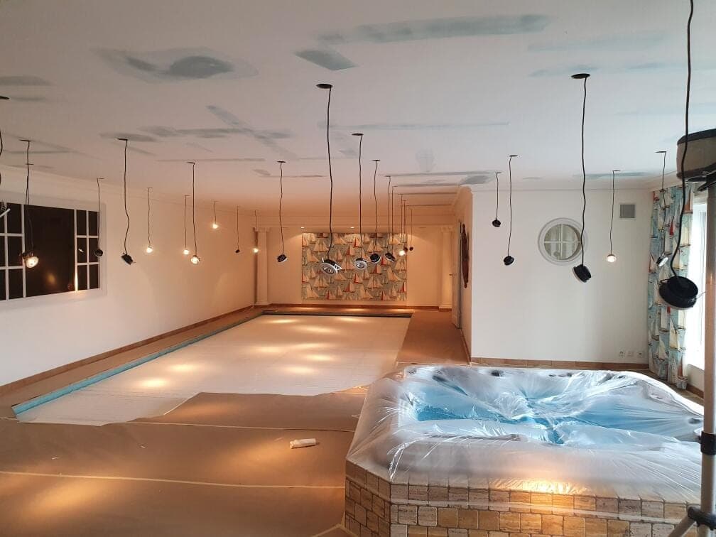 Poolrum under arbete med spacklade ytor, pool och spa täckta